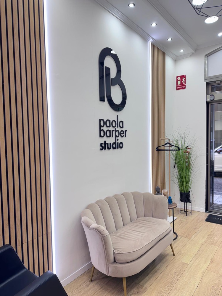 Recepción Paola Barber Studio — logo y sofá